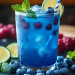 Refreshing glass of Chill Blue Razz Juice with fresh raspberries