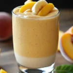 Creamy banana peach smoothie recipe with fresh fruit garnish